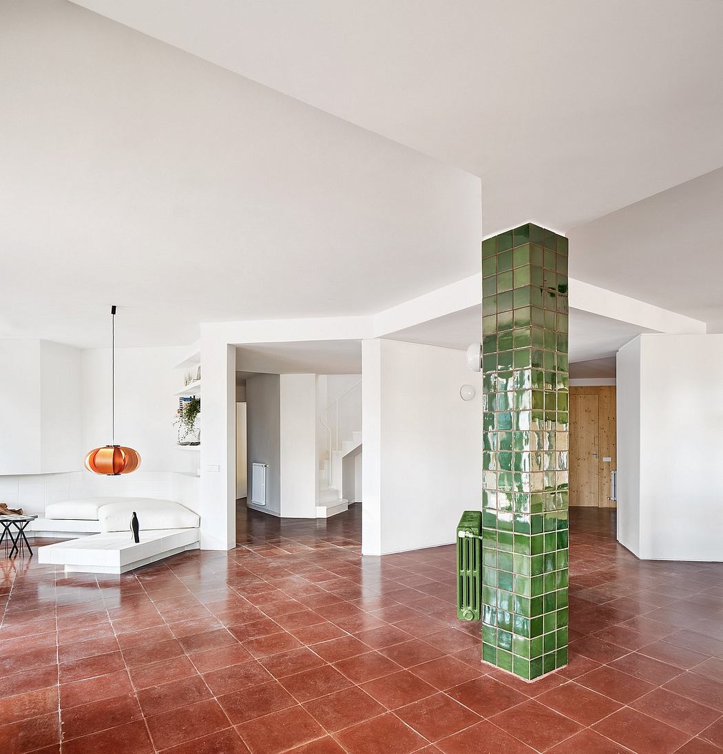 Minimalist interior with white walls, a green tiled pillar, and terracotta