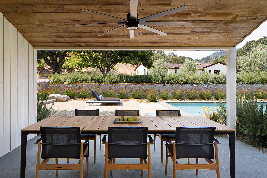 Wooden outdoor dining area with a view of a pool.