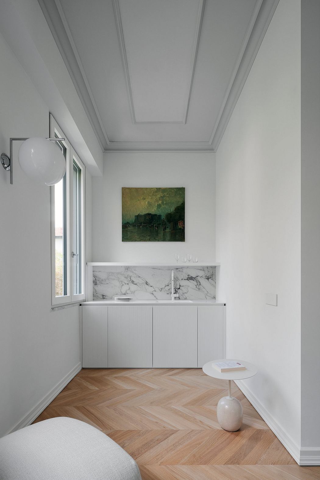Elegant interior with herringbone floor, classic ceiling moldings, and marble