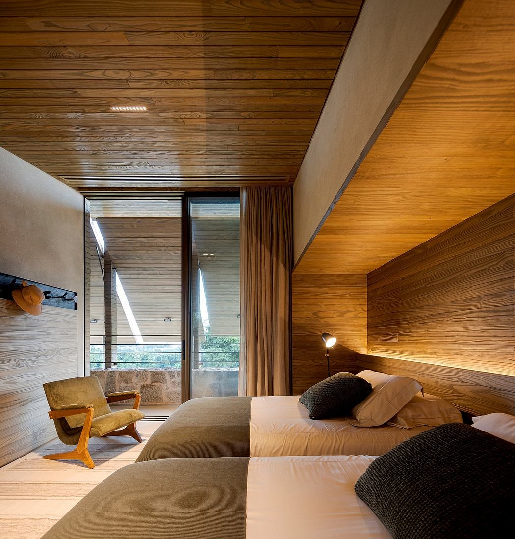 Contemporary bedroom with wooden walls, slanted ceiling, and large window.