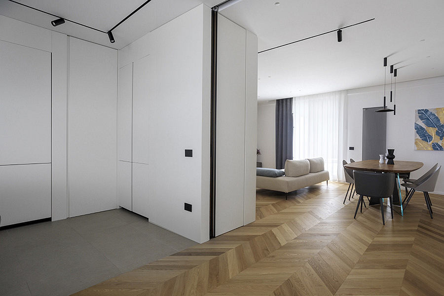 Modern minimalistic interior with herringbone floor and white walls.