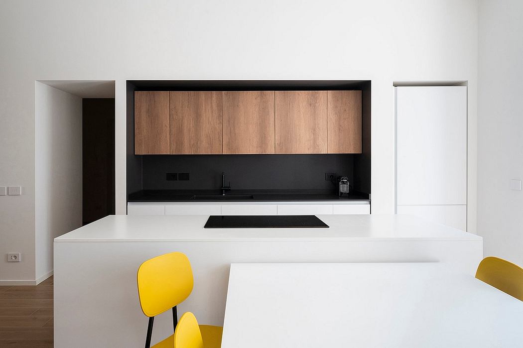 Sleek kitchen with wood accents and yellow chairs.