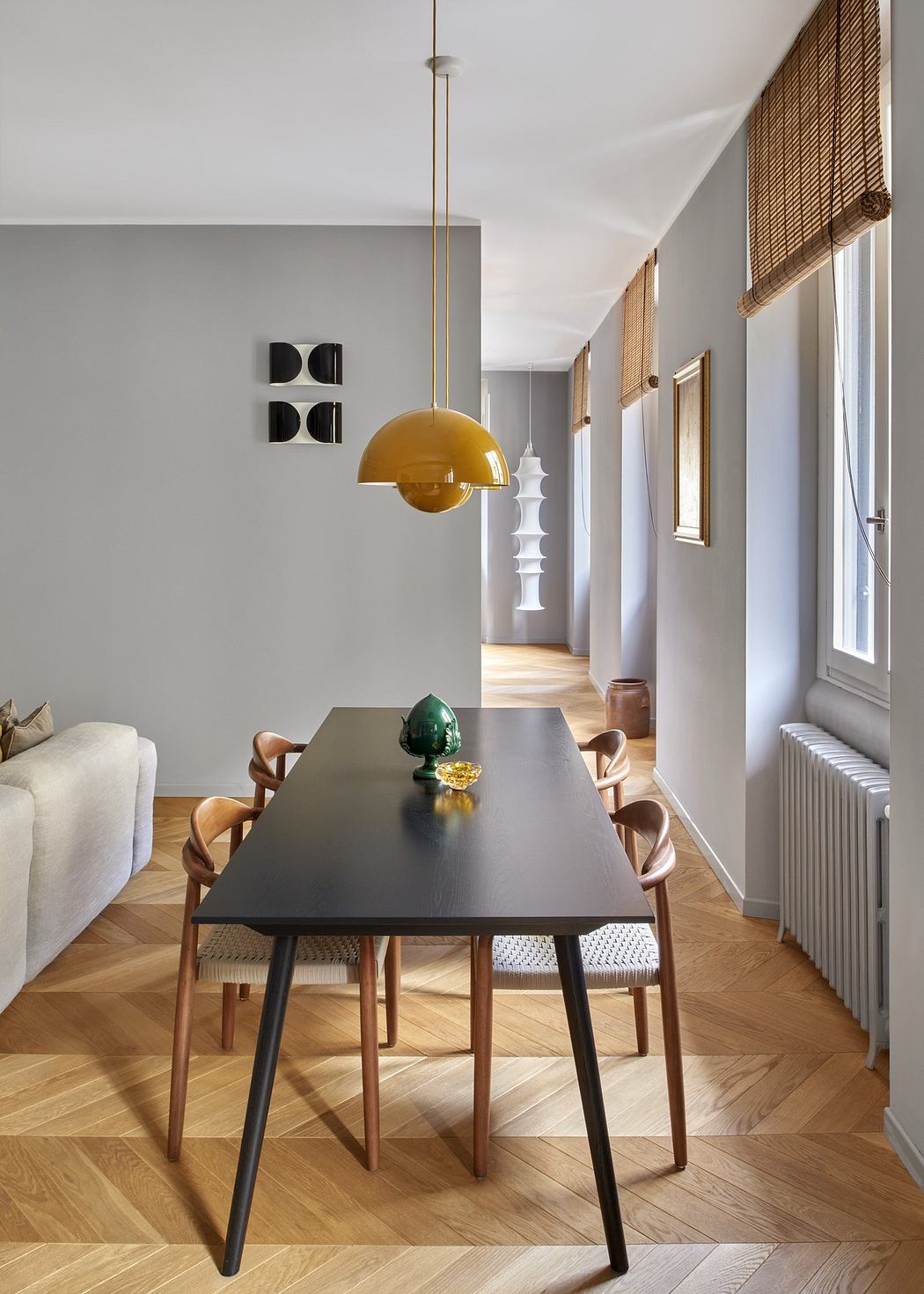 Contemporary dining room with a yellow pendant lamp and wooden floors.