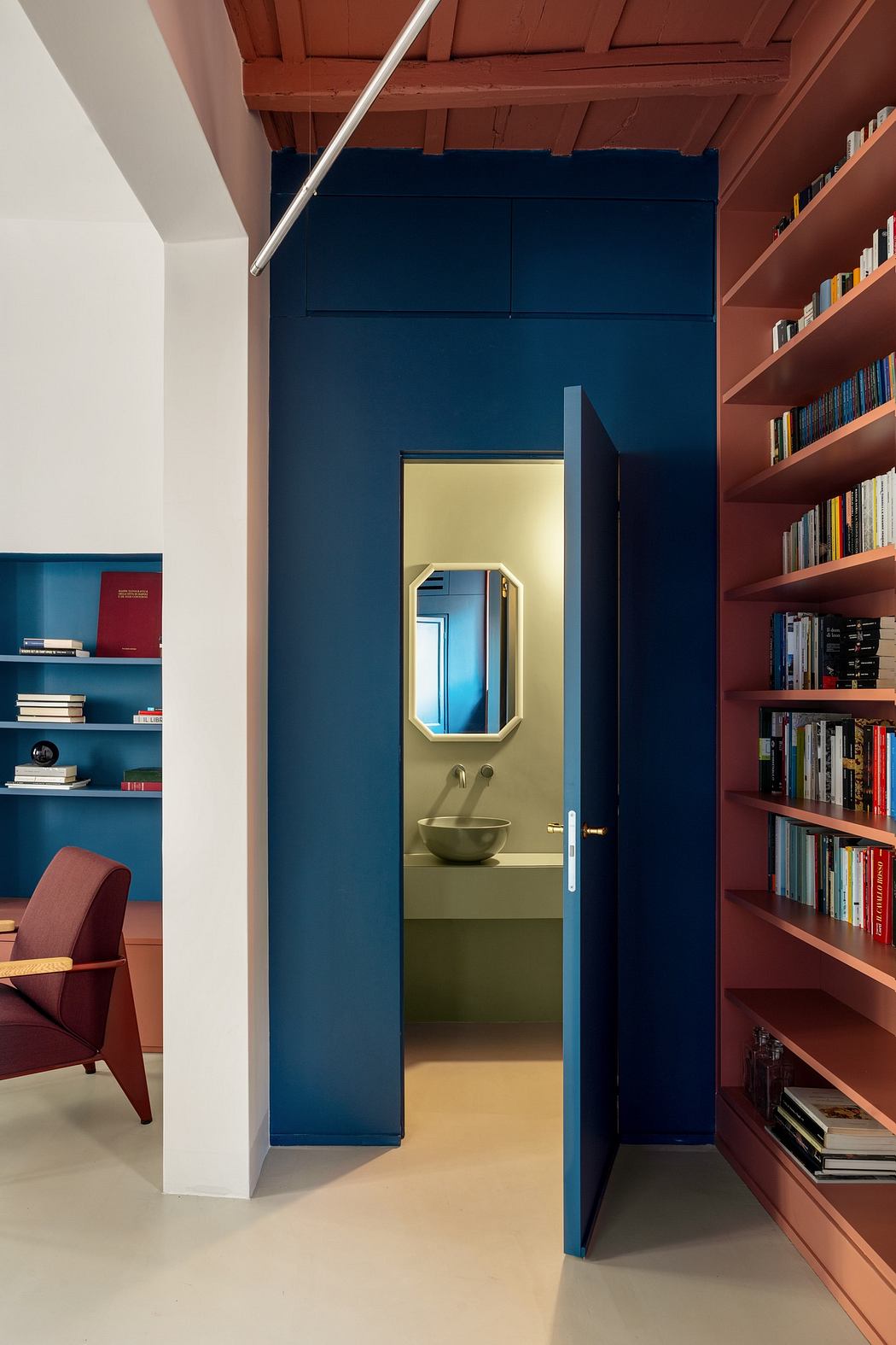 Modern interior with blue doorway and terracotta bookshelves.
