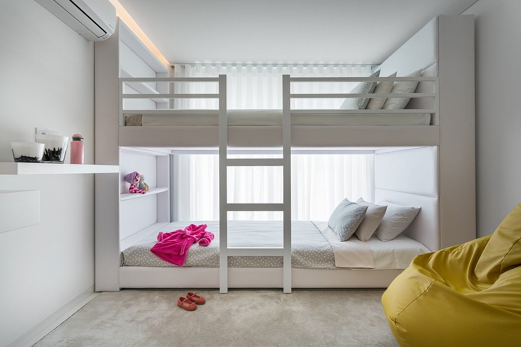 Sleek white bunk bed in a minimalist room with cozy seating.