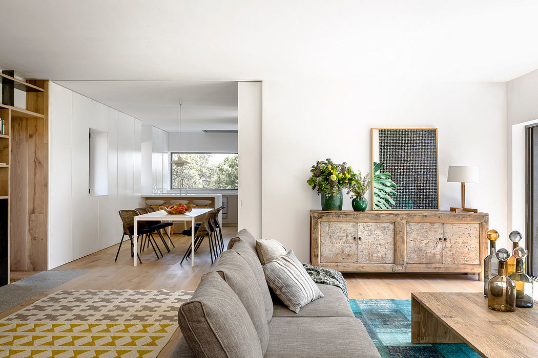 Modern living room with dining area, wooden furniture, and patterned rug.