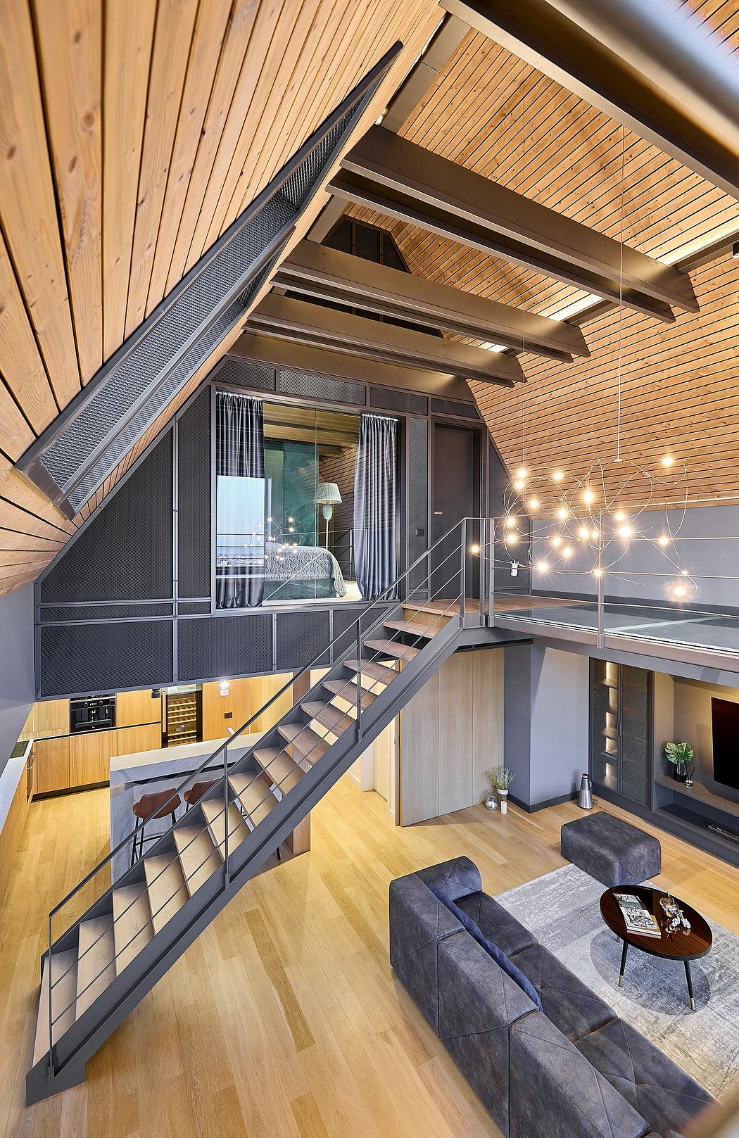 Contemporary loft with wooden ceiling, metal staircase, and hanging lights.
