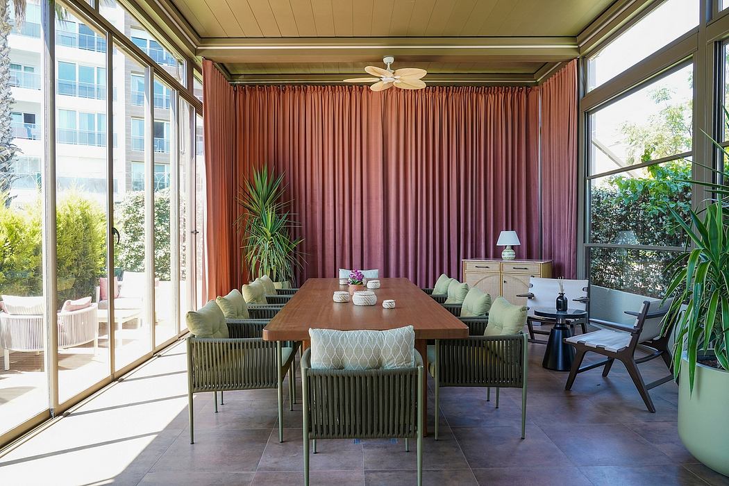 Contemporary sunroom with terracotta curtains, dining set, and greenery