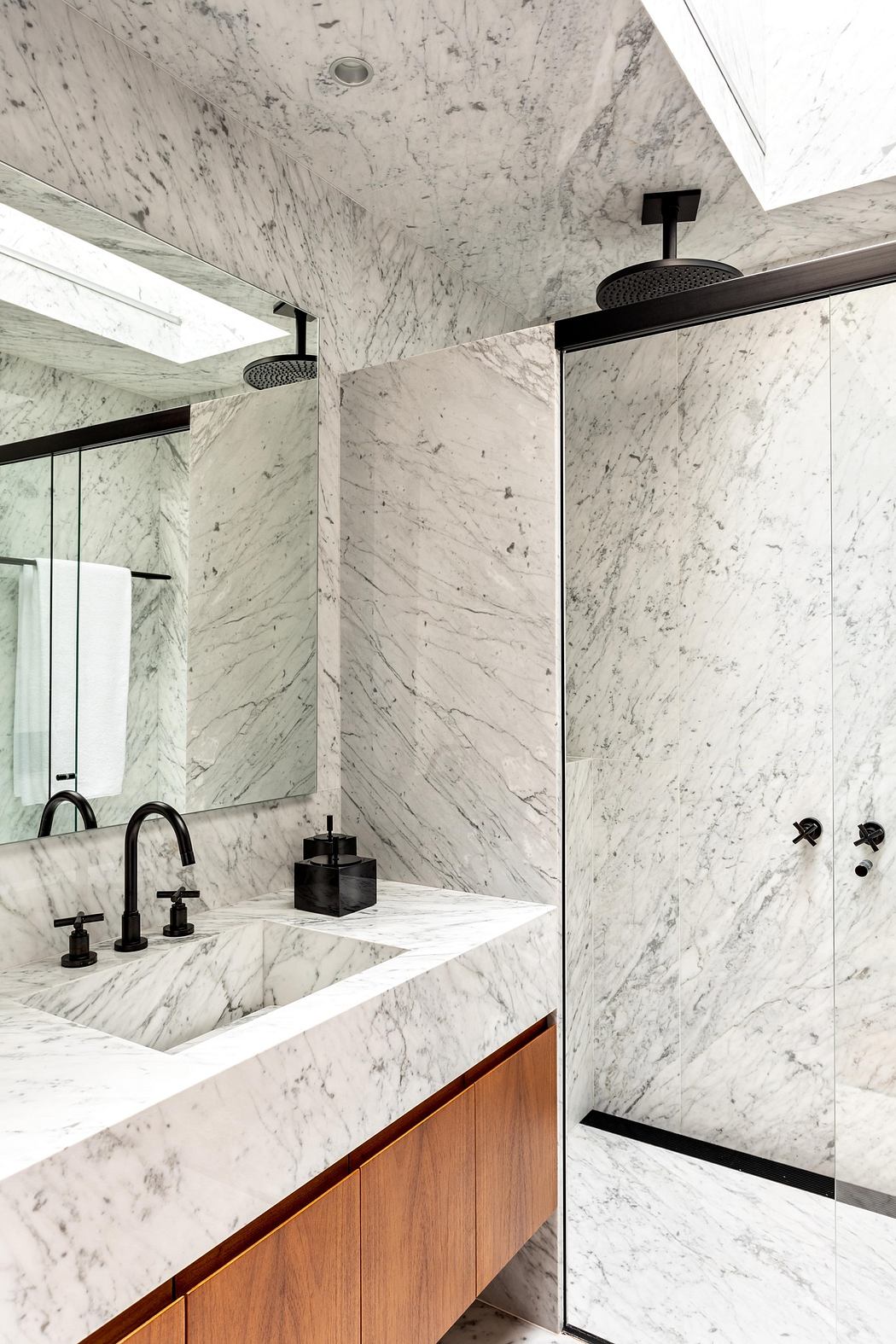 Elegant bathroom with marble walls and wooden vanity.