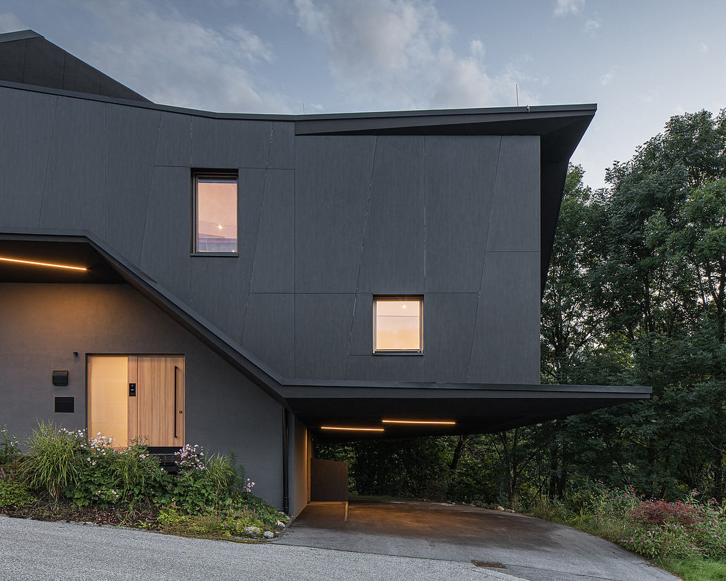 Modern house with angular design and black exterior at dusk.