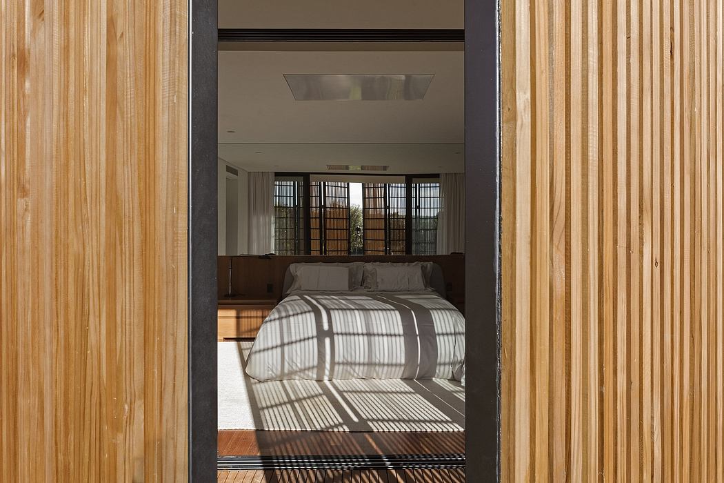 Contemporary bedroom with wooden slats and shadow patterns.