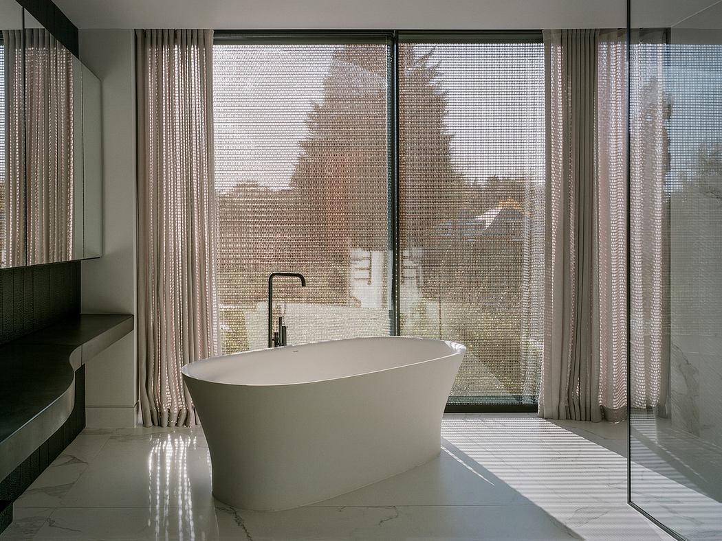 Minimalist bathroom with freestanding tub and floor-to-ceiling windows.