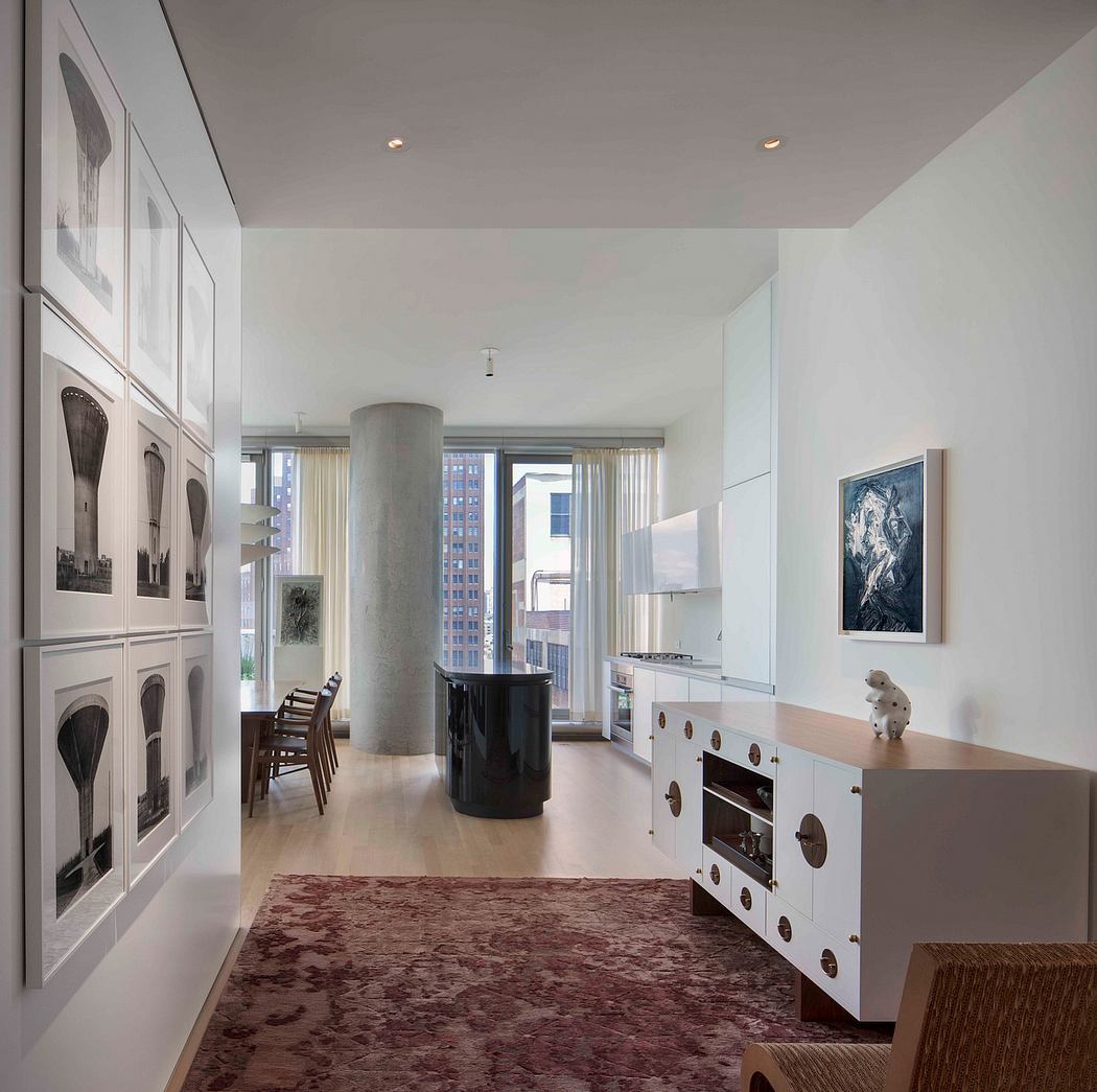 Minimalist interior with art display, white cabinets, and large windows.