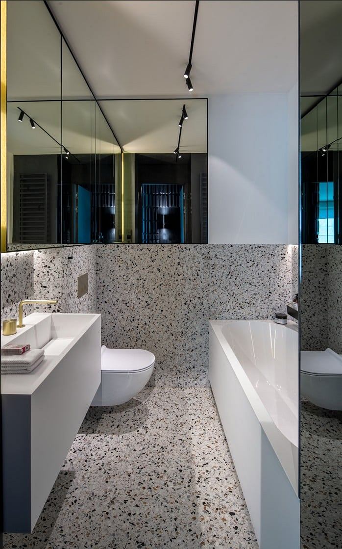 Contemporary bathroom with terrazzo flooring and mirrored walls.