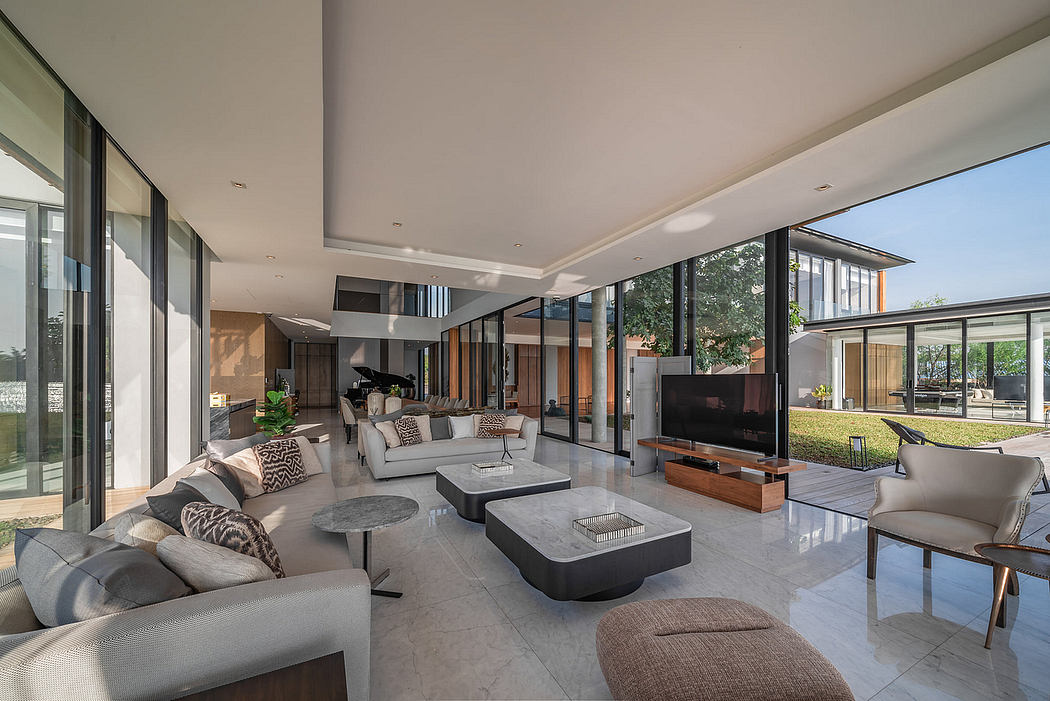Modern living room with elegant furniture and large windows overlooking a garden.