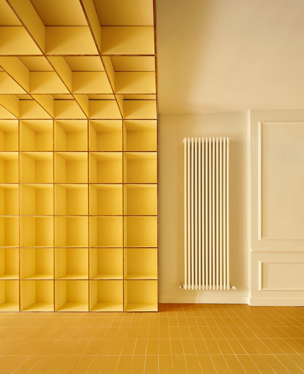 Contemporary yellow cubic shelving next to a traditional white radiator.