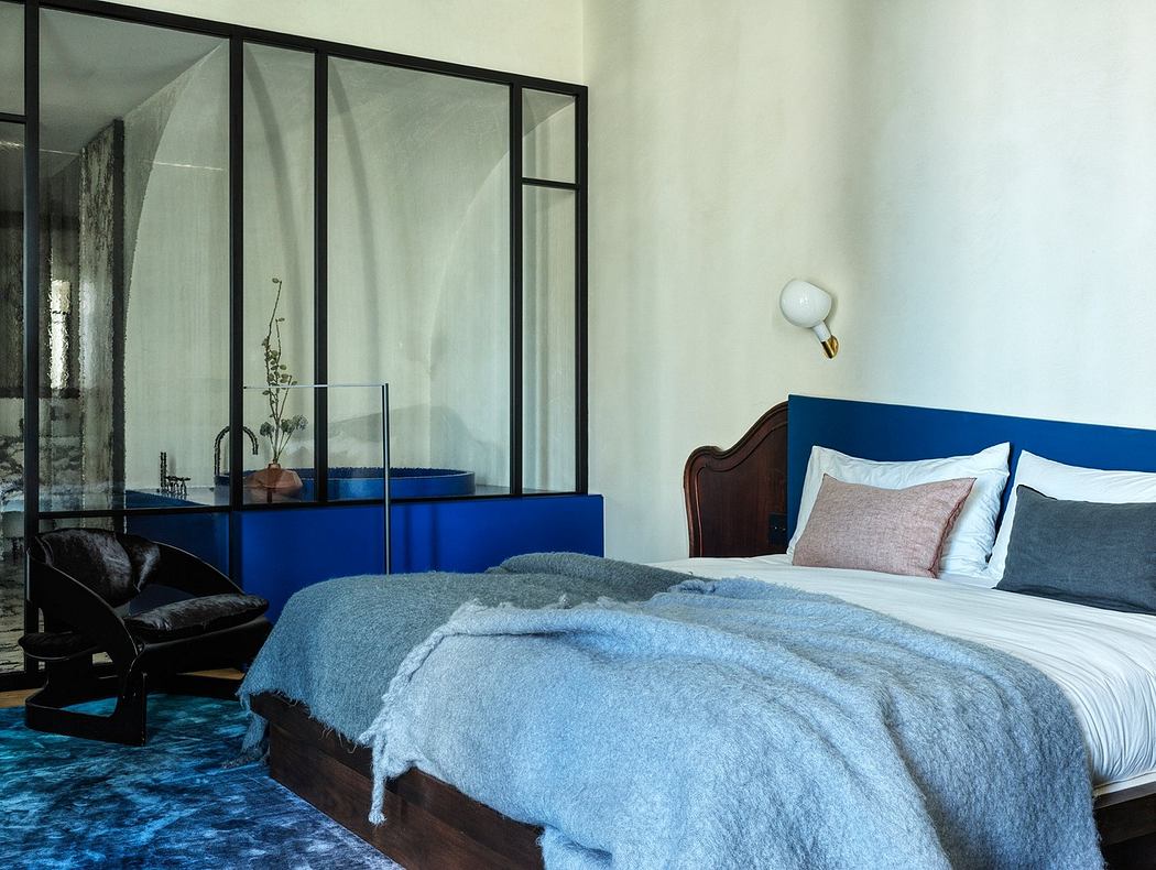 Contemporary bedroom with glass partition and blue accents.