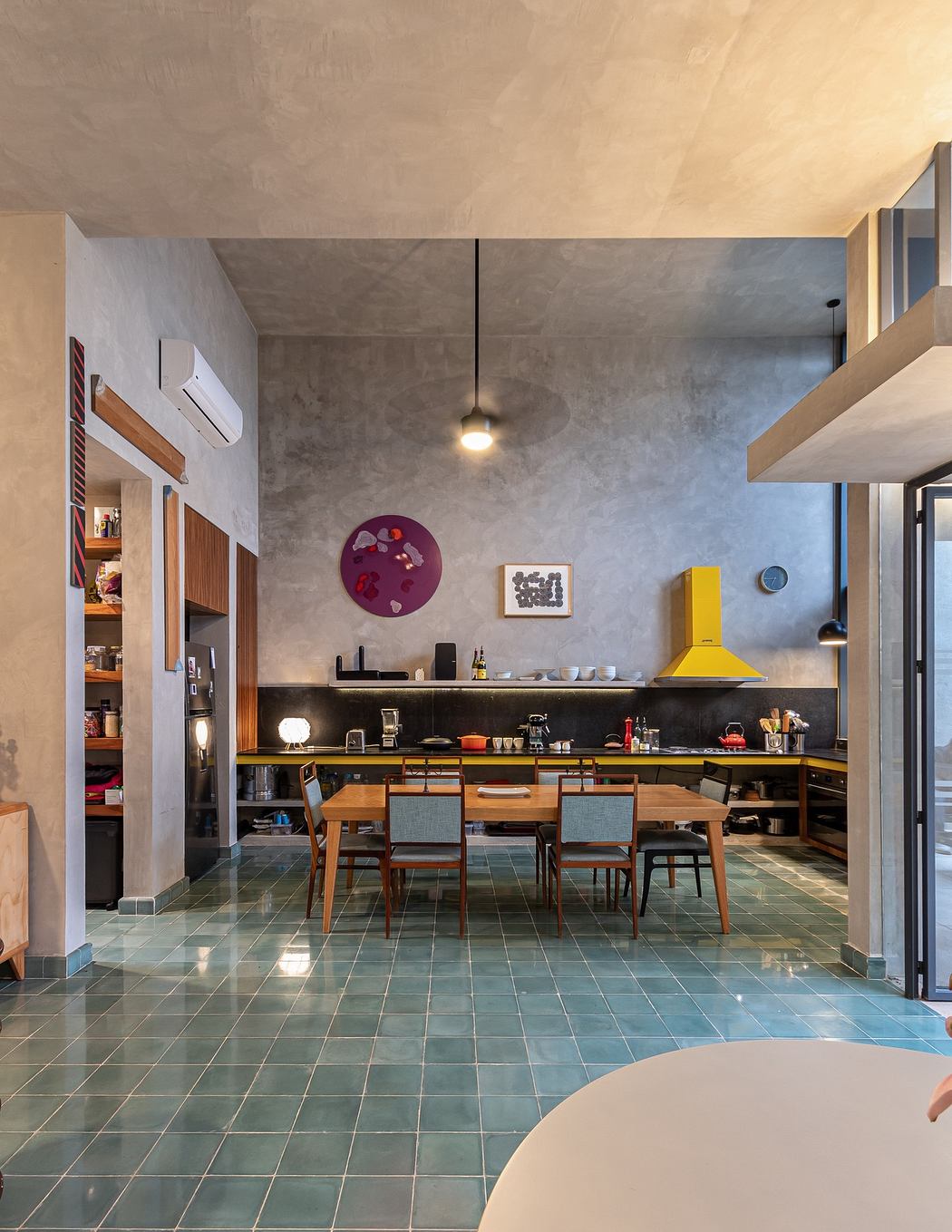 Industrial-chic dining area with concrete walls and colorful accents.