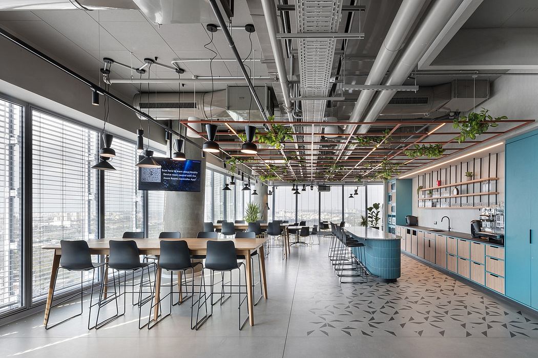Modern office break room with tables, chairs, and blue cabinets.