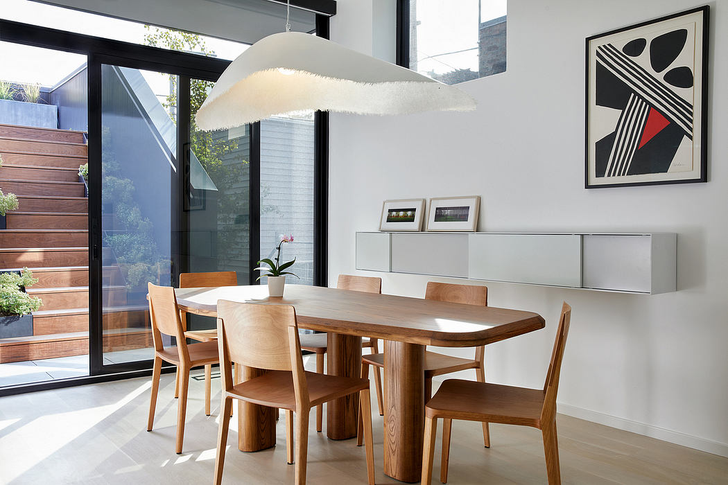 Modern dining room with wooden table, chairs, and unique pendant light.