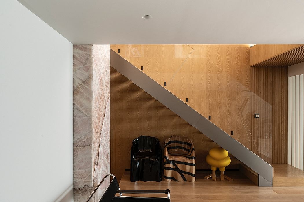 Contemporary stairwell with wood paneling and unique chair designs.