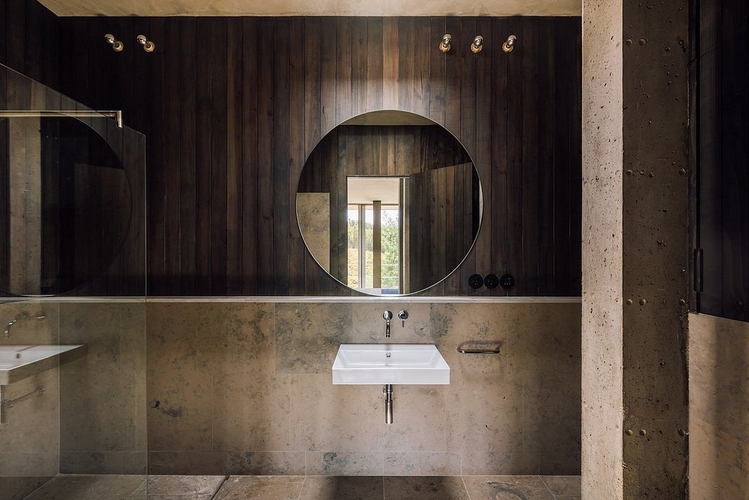 Contemporary bathroom with round mirror and wooden wall paneling.