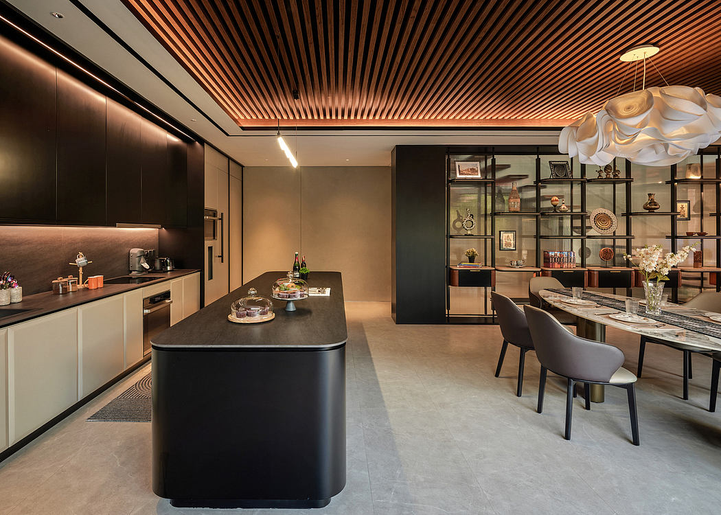Modern kitchen with island and adjacent dining area with decorative lighting.