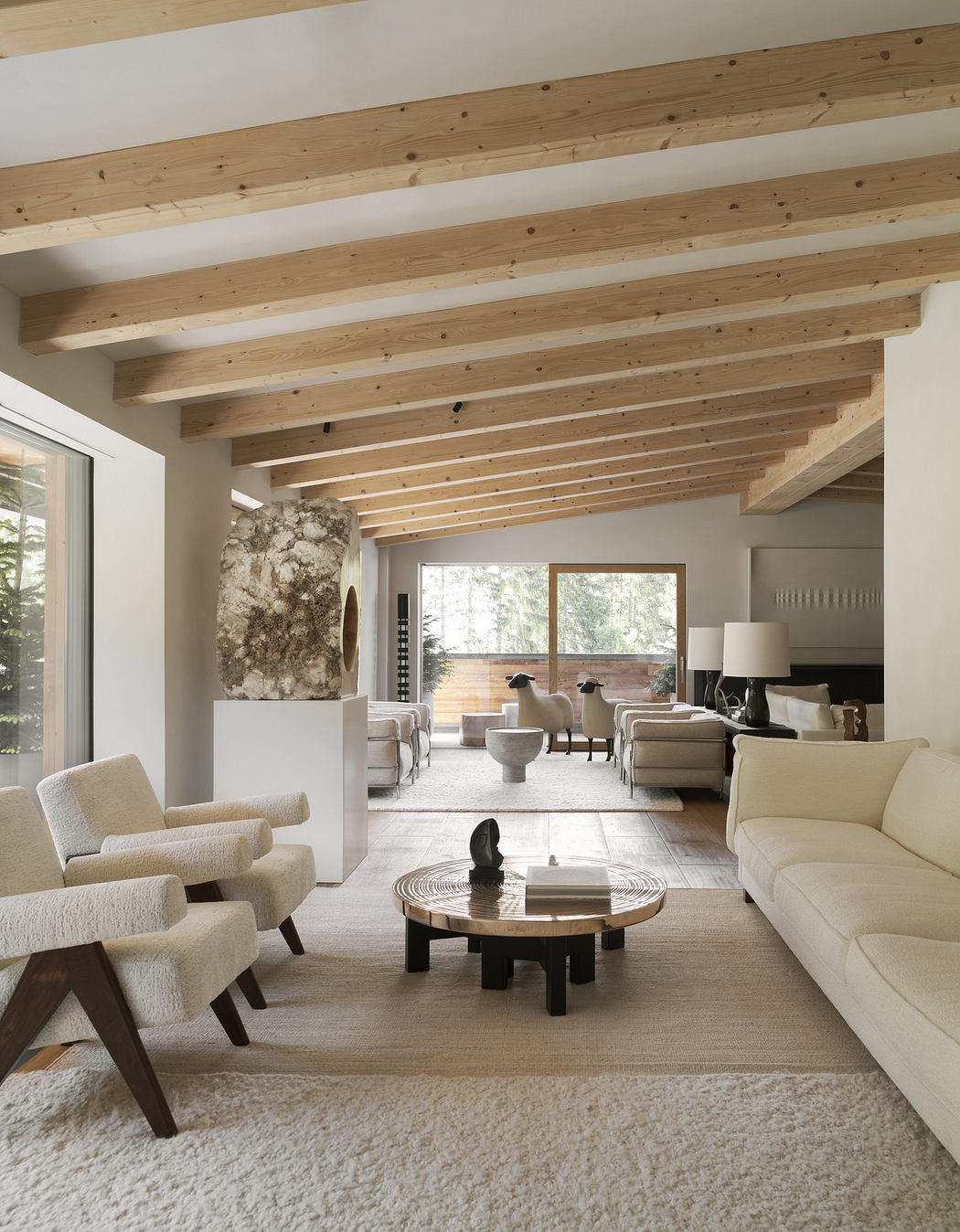 Modern living room with wooden ceiling beams, neutral tones, and minimalist decor.