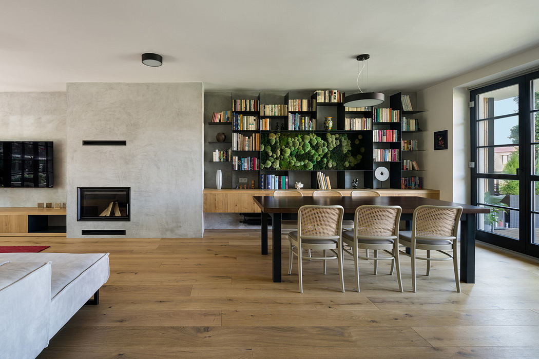 Modern living room with fireplace, bookshelf, and dining area.