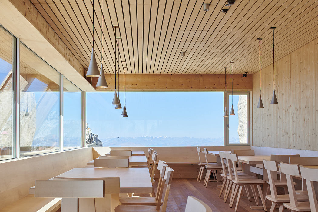 Spacious wooden interior with panoramic windows and mountain views.