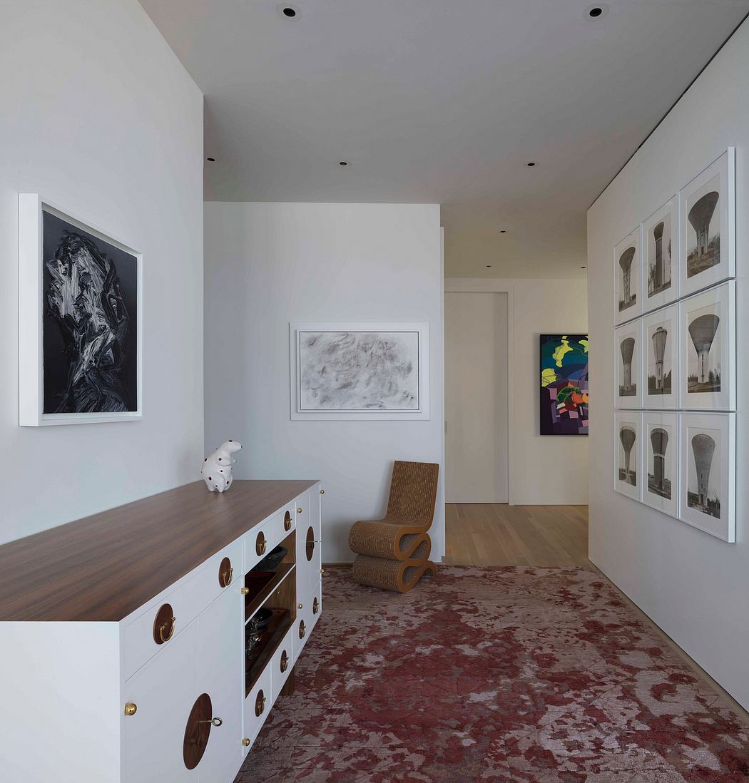 Modern room interior with white walls, art displays, and a patterned red rug