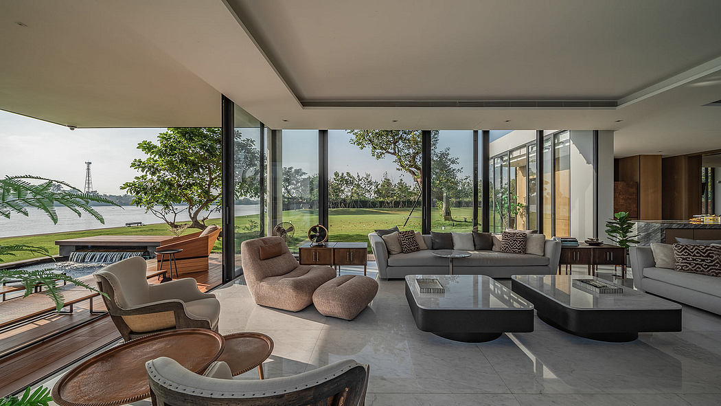 Modern living room with large glass windows overlooking greenery.