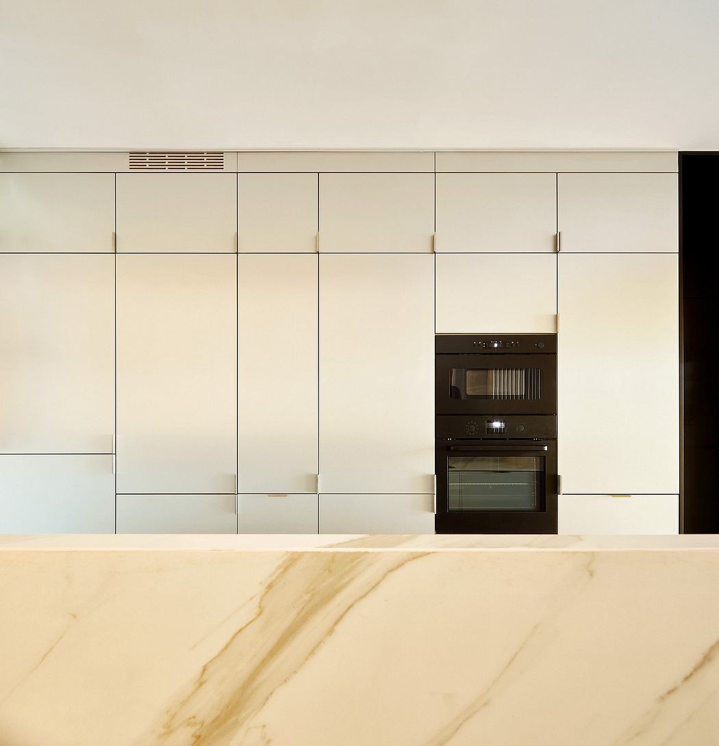 Sleek kitchen with minimalist cabinets and built-in ovens.