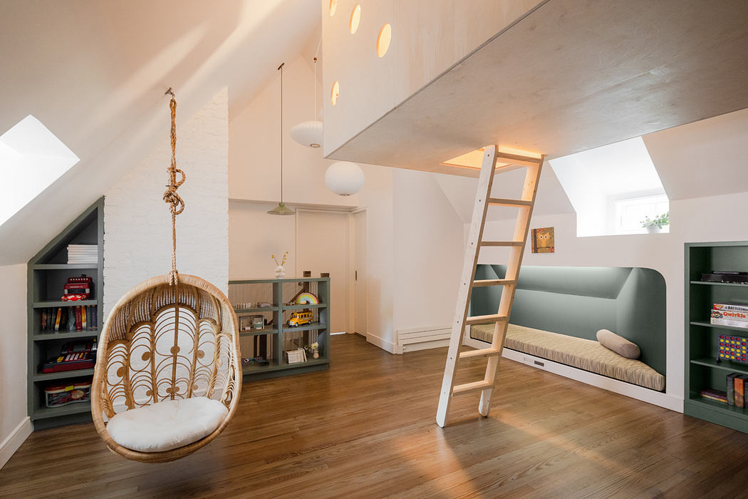 Modern attic room with hanging chair, bookshelf, sofa, and ladder.