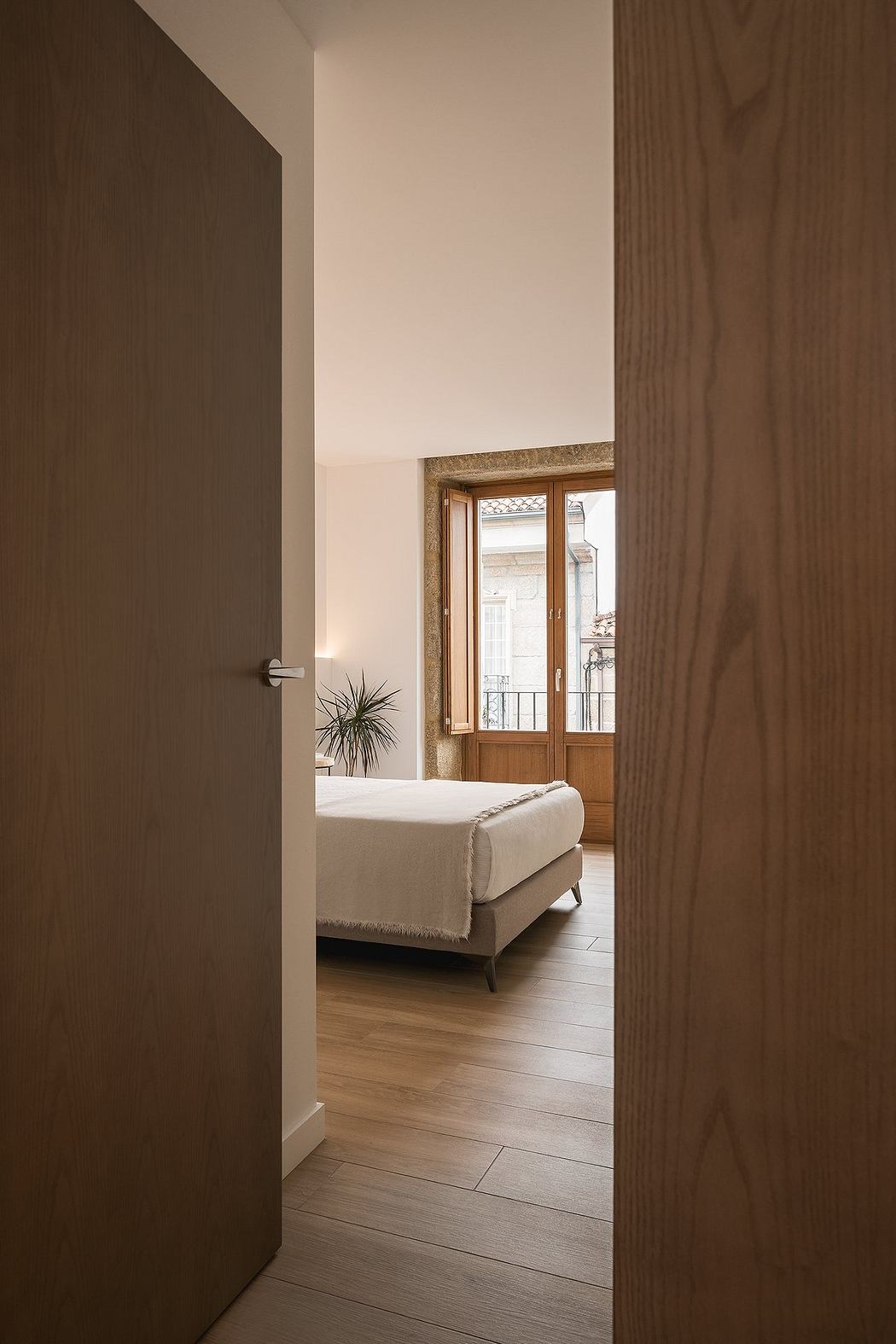 Contemporary bedroom with wooden floors and natural light.