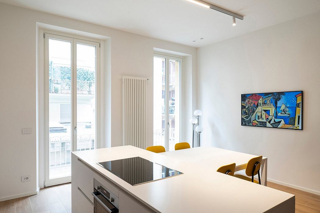 Modern kitchen with white cabinets, a dining table, and colorful artwork on the wall
