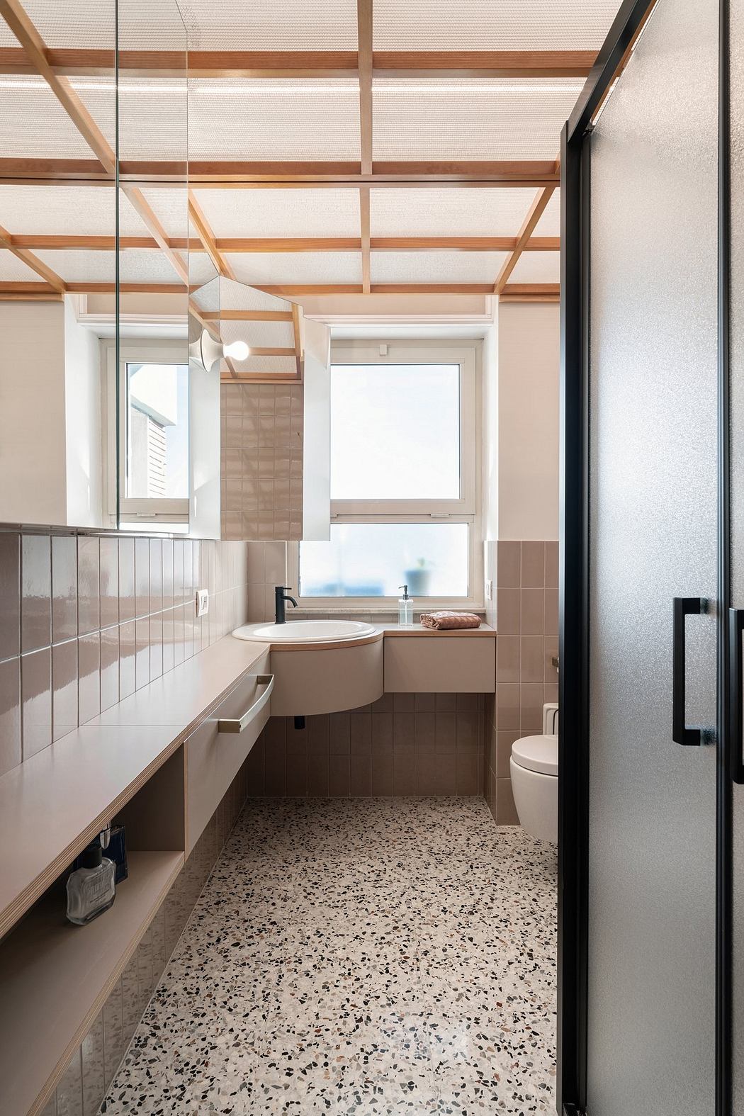 Modern bathroom interior with wooden ceiling beams and terrazzo flooring.