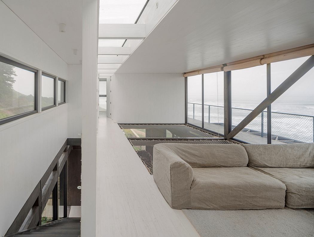 Sleek interior hallway with ocean view and minimalist couch.