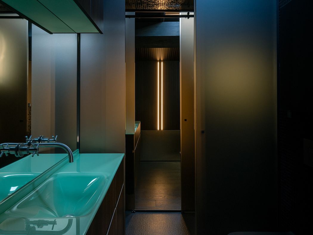Modern bathroom with blue sink and dim corridor lighting.