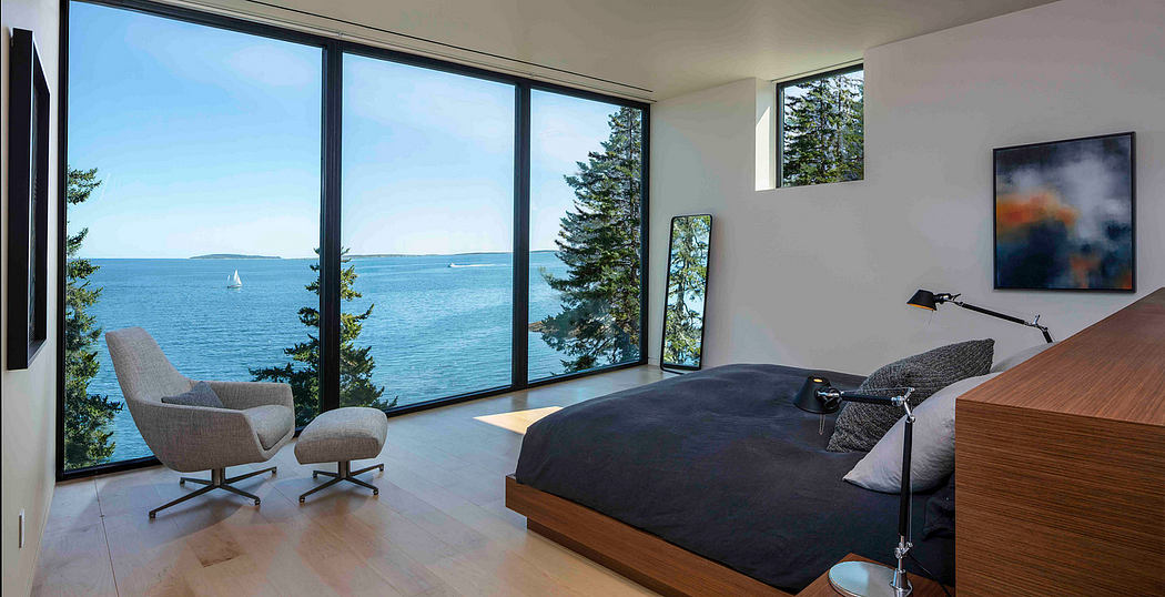 Modern bedroom with large windows overlooking the sea.