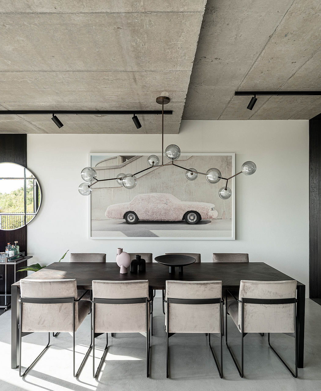 Modern dining room with concrete ceiling, black table, beige chairs, and abstract art