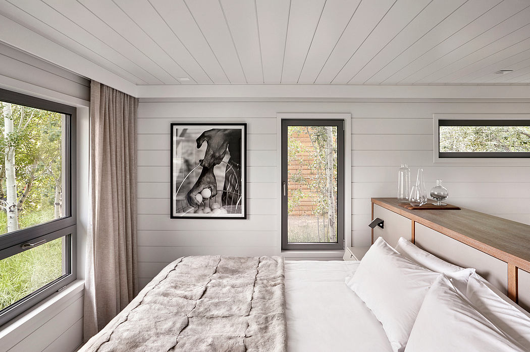 Contemporary bedroom with sleek furnishings and artwork.