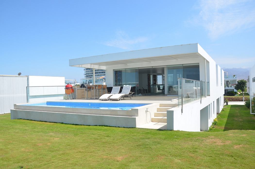 Modern white house with large windows, lawn, and an outdoor swimming pool.