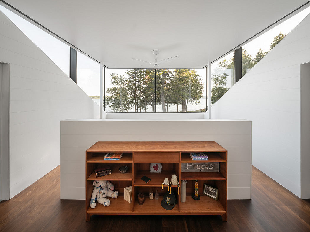 Minimalist room with wooden shelving and a large window showcasing trees.