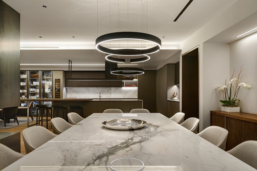Modern kitchen with marble island and circular pendant lights.