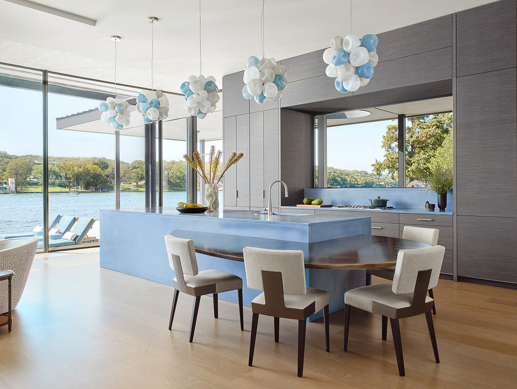 Modern kitchen interior with large windows and lake view.