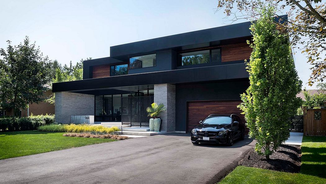 Contemporary house with flat roofs, dark cladding, and large windows, with