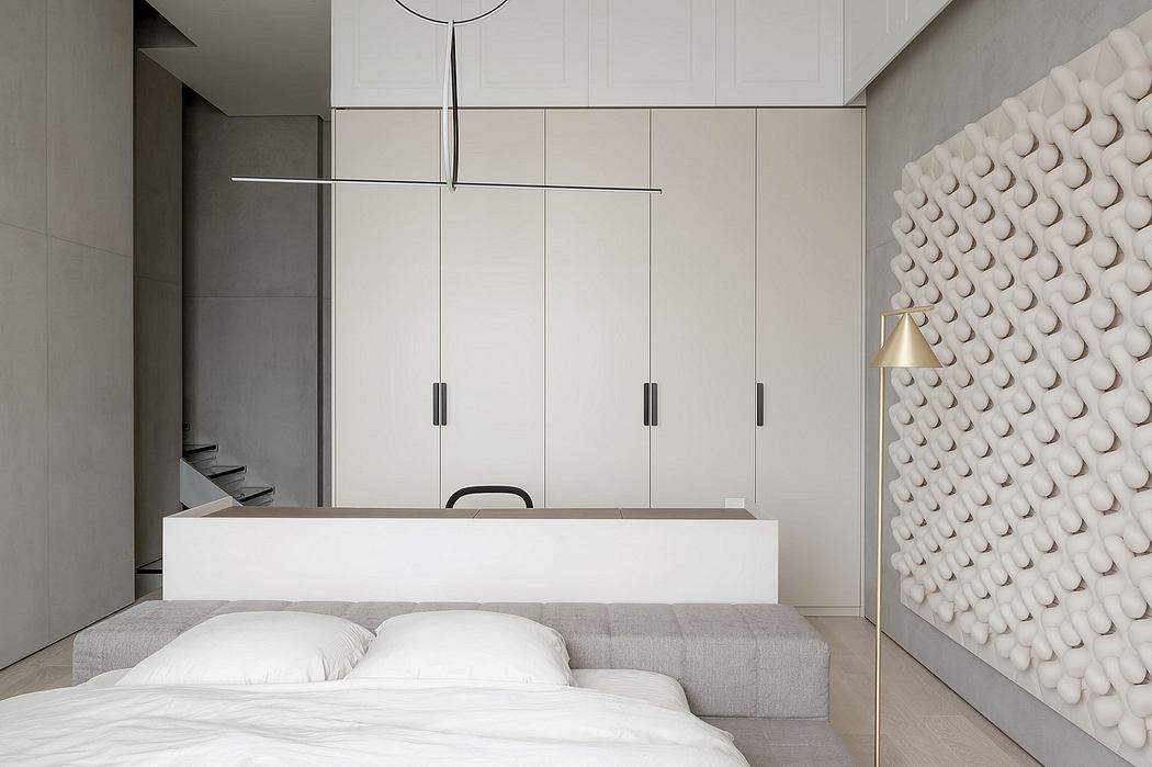Minimalist bedroom with textured wall and sleek furnishings.