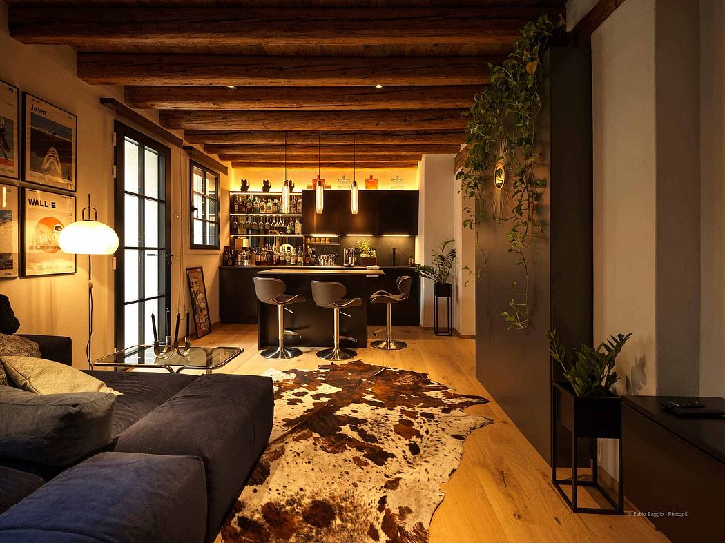 Cozy living room with a bar area, exposed ceiling beams, and warm lighting