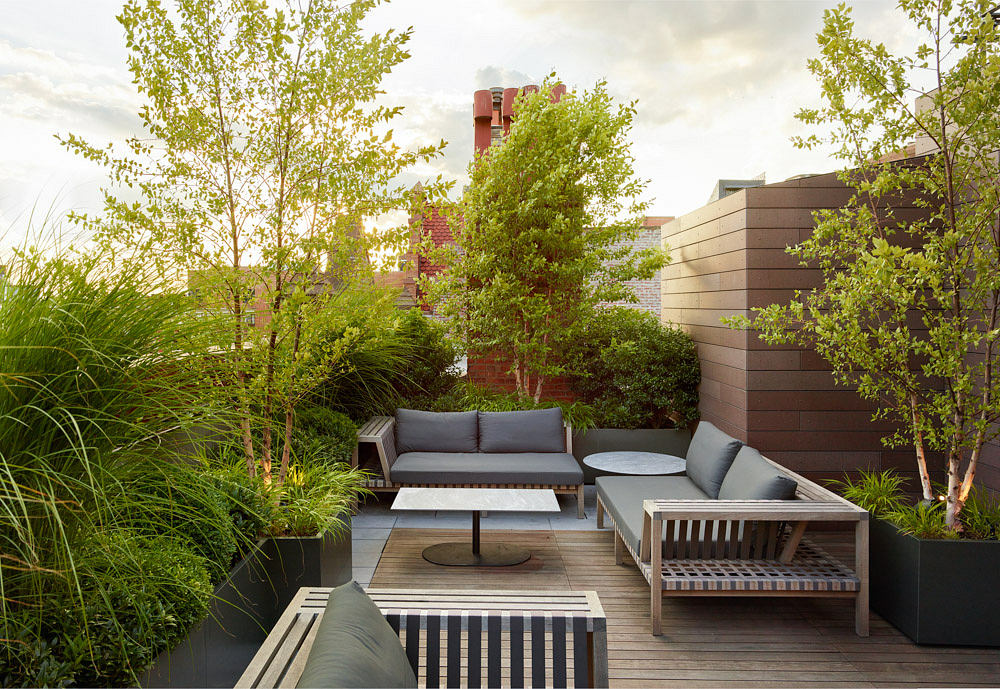 Contemporary rooftop garden with outdoor seating and lush greenery.